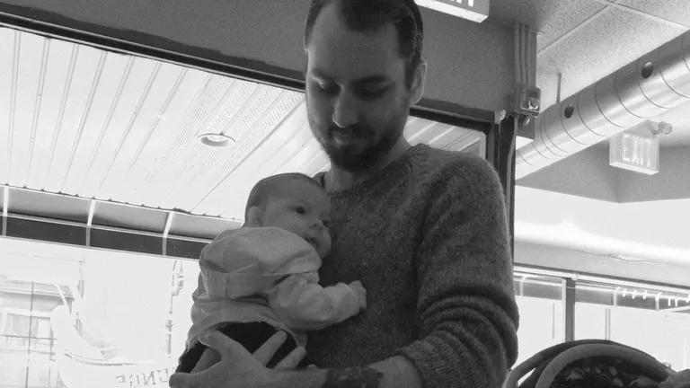 A black-and-white photograph of Tanner holding Mazie as a baby.