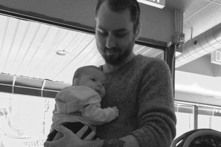 A black-and-white photograph of Tanner holding Mazie as a baby.